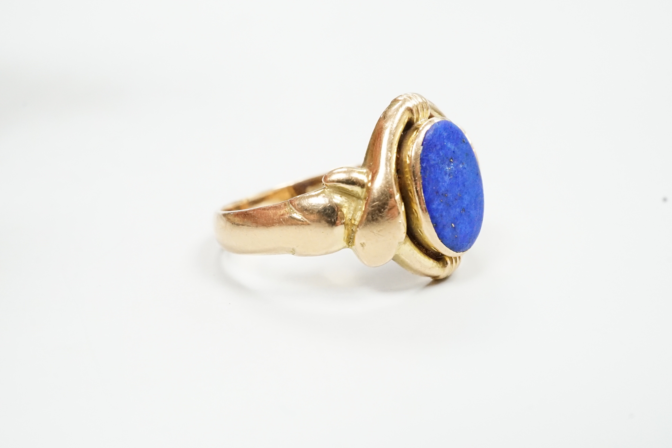 A 585 and lapis lazuli set ring, with twin serpent head terminals, size Q, gross weight 6.2 grams.